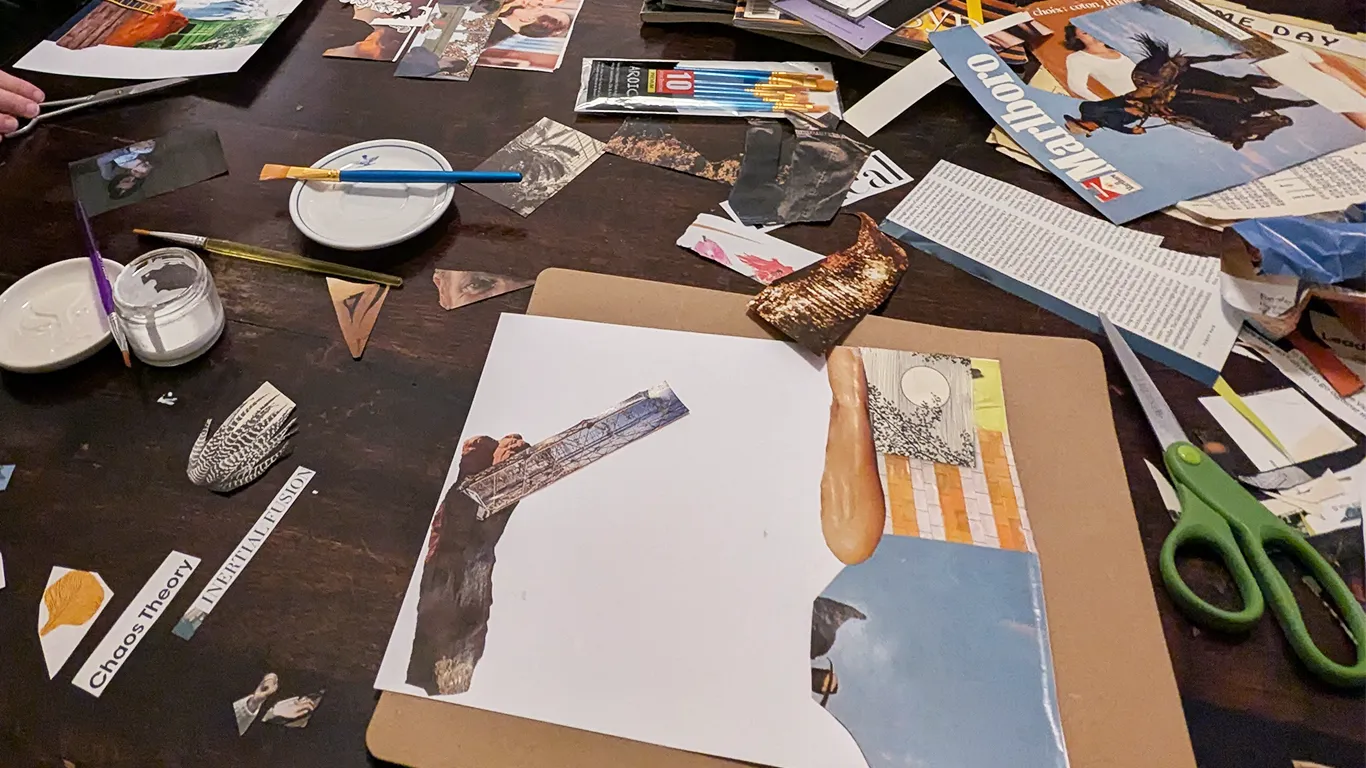 A table covered in cutout scraps of paper and tools for collaging.
